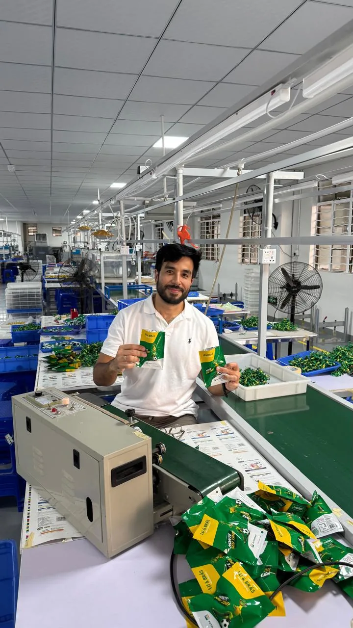 João na linha de produção de uma fábrica parceira, conferindo brindes